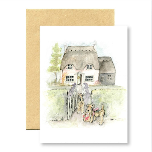 Greeting card with a illustration of a thatched cottage and dogs on a white background